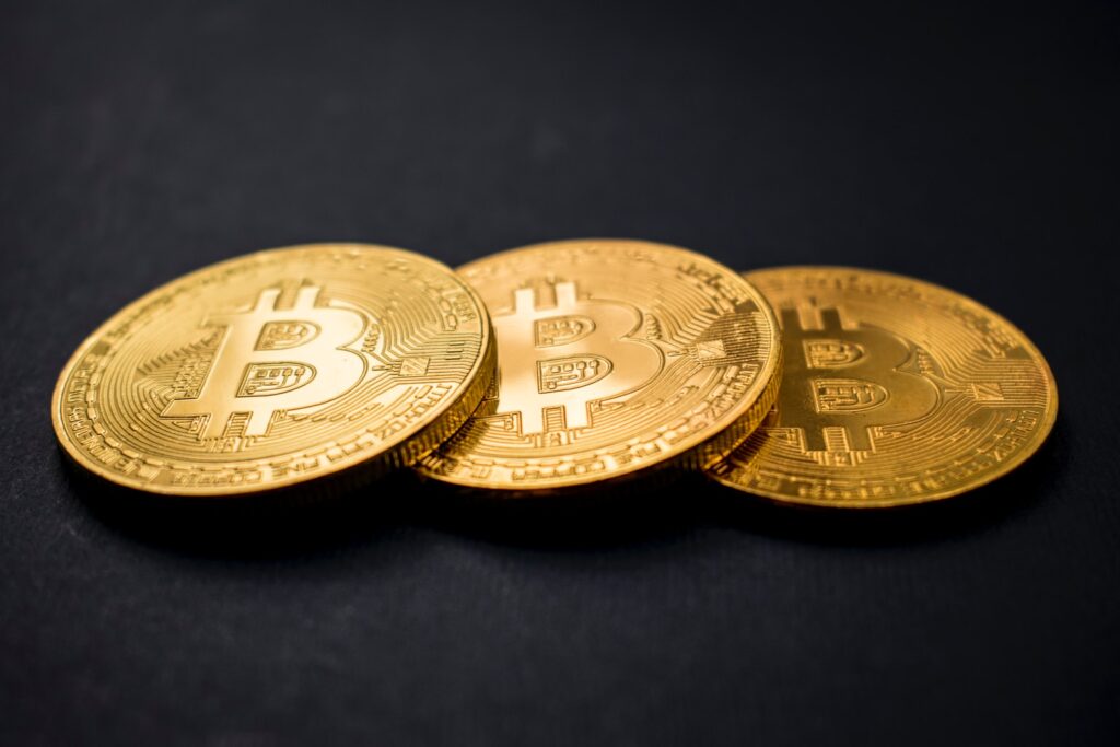 trois bitcoins de couleur or sur une surface noire