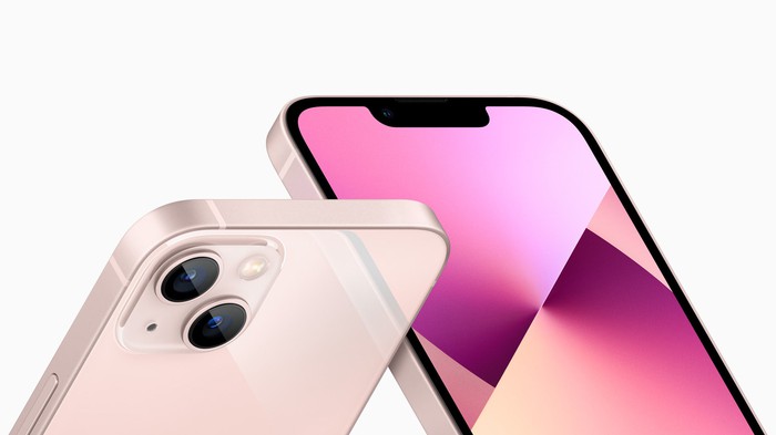 Deux iPhone 13s de couleur rose posés en diagonale montrant les vues avant et arrière.