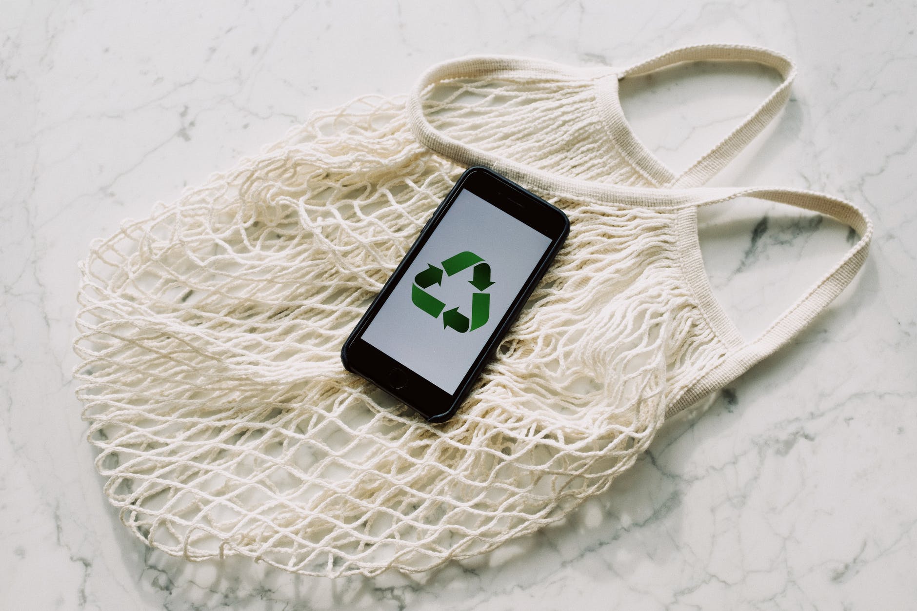 téléphone portable avec panneau de recyclage vert et sac en filet