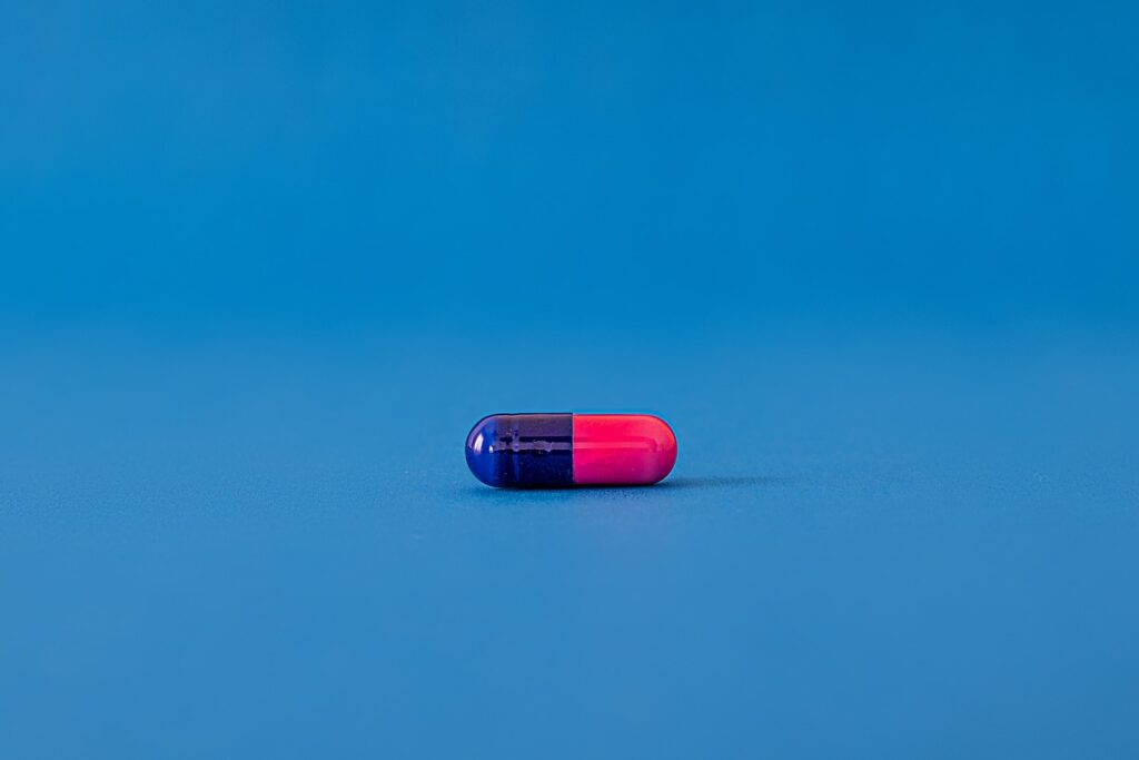 pilule rouge et bleue sur une surface bleue
