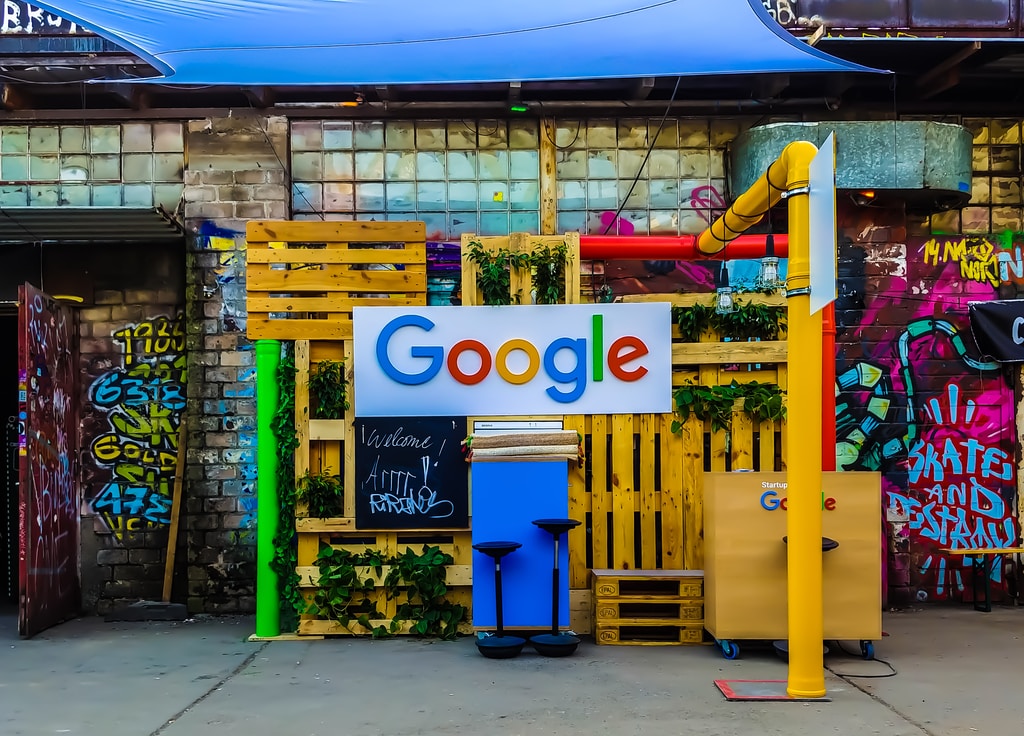 logo google à côté d'un bâtiment près de murs peints pendant la journée